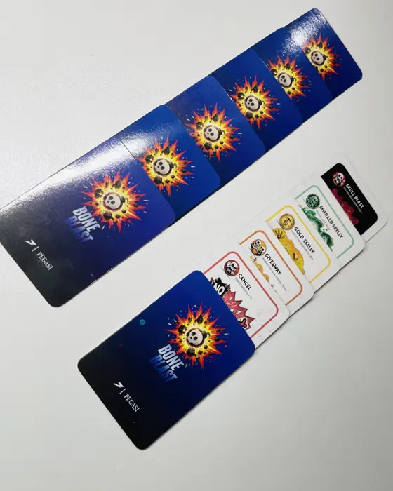 A row of blue Bone Blast card backs above a fan of card fronts